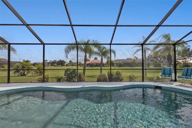 view of pool with a lawn, a patio area, and glass enclosure