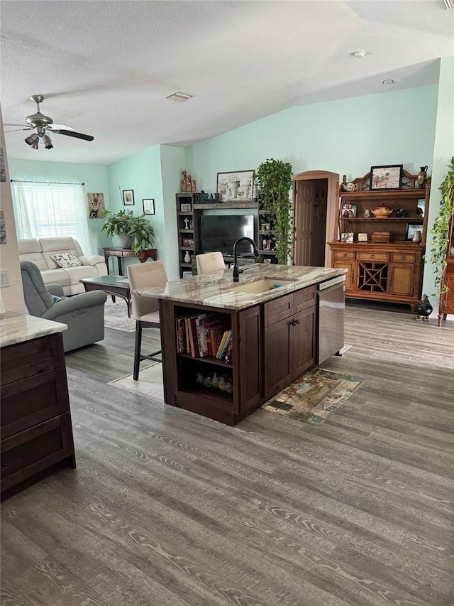 kitchen with sink, stainless steel dishwasher, dark hardwood / wood-style flooring, and a kitchen island with sink