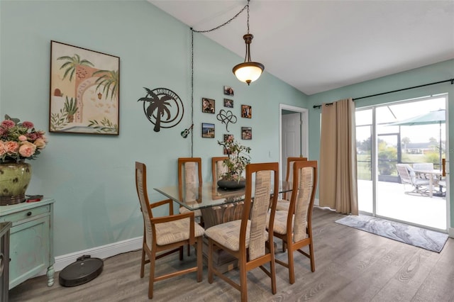 dining area with vaulted ceiling and hardwood / wood-style flooring