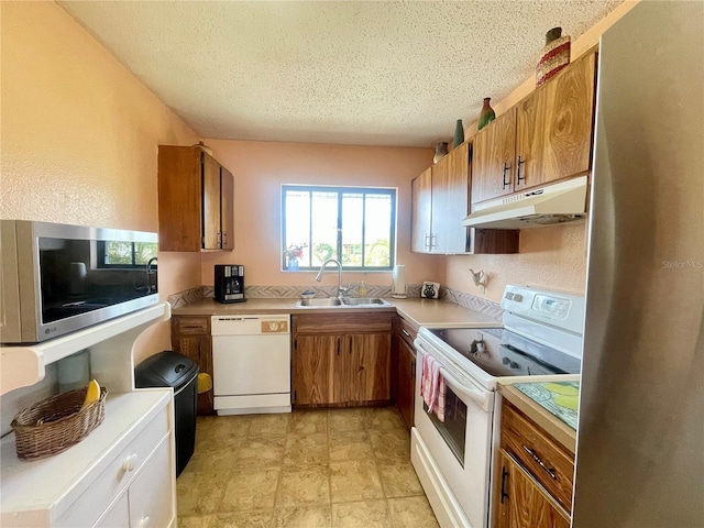 kitchen with sink, a textured ceiling, and appliances with stainless steel finishes