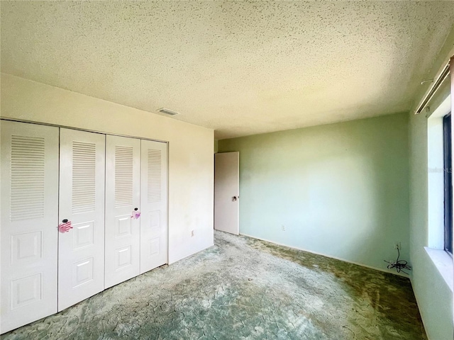 unfurnished bedroom with a textured ceiling and a closet