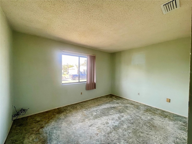 empty room with a textured ceiling and carpet flooring