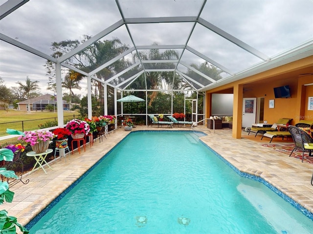 view of swimming pool with a lanai, outdoor lounge area, and a patio