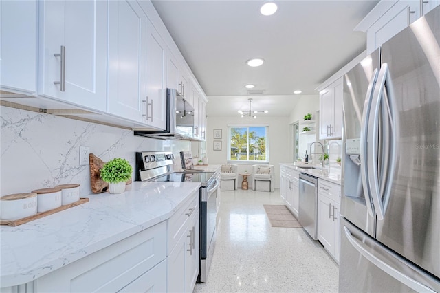 kitchen with white cabinetry, appliances with stainless steel finishes, tasteful backsplash, a notable chandelier, and sink