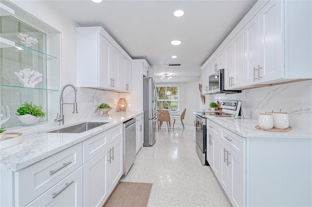 kitchen featuring sink, white cabinets, appliances with stainless steel finishes, and tasteful backsplash