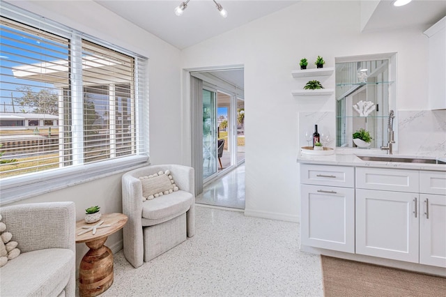 living area featuring wet bar, lofted ceiling, and a chandelier