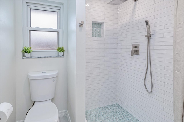 bathroom with toilet and a tile shower