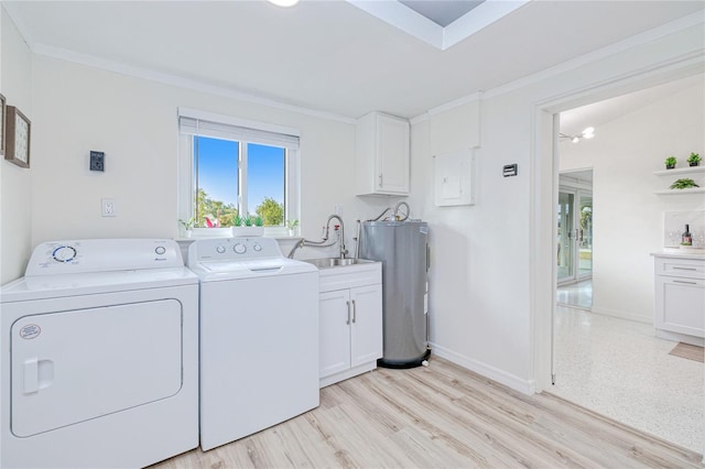 washroom featuring sink, crown molding, washing machine and clothes dryer, and cabinets