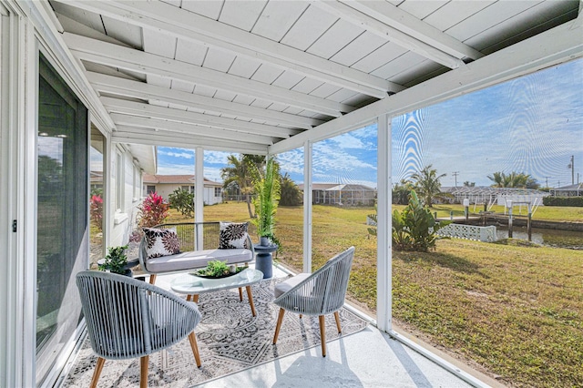 sunroom featuring plenty of natural light and beam ceiling