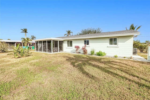 rear view of property featuring a sunroom and a lawn