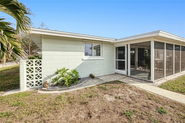 back of house with a sunroom and a yard