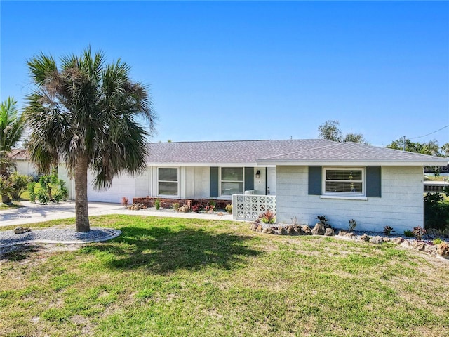 ranch-style house with an attached garage, covered porch, concrete driveway, and a front yard