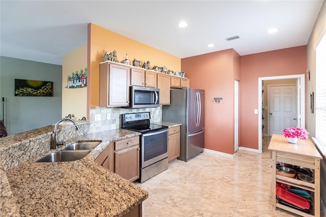 kitchen with light stone countertops, sink, backsplash, and appliances with stainless steel finishes