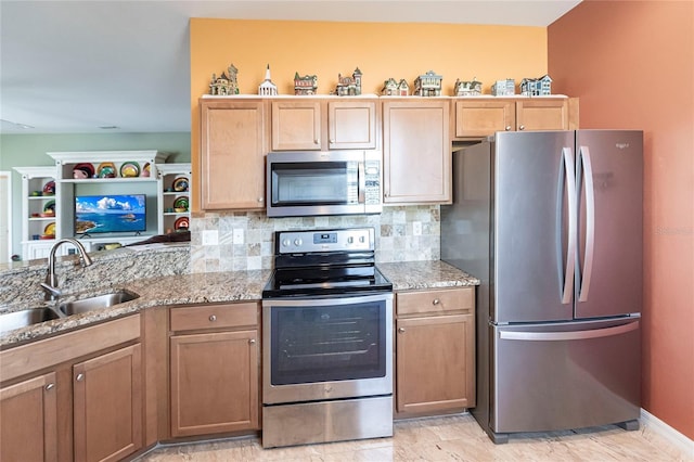 kitchen featuring decorative backsplash, sink, light stone counters, and stainless steel appliances