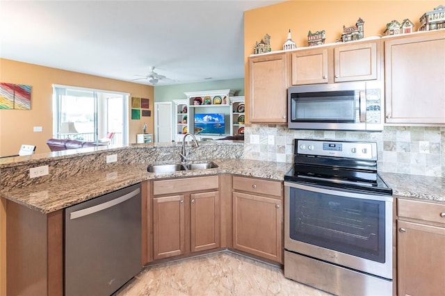 kitchen with decorative backsplash, sink, appliances with stainless steel finishes, and kitchen peninsula