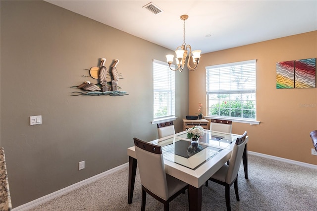 carpeted dining area with an inviting chandelier