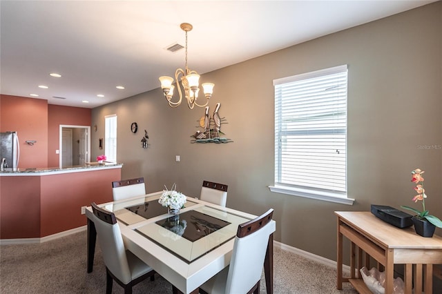 dining area featuring carpet and a notable chandelier