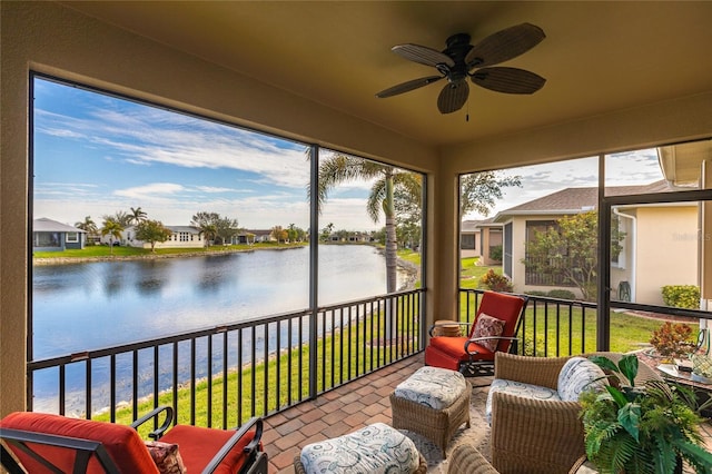 sunroom featuring a water view and ceiling fan