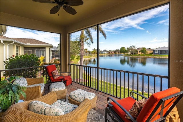 sunroom / solarium featuring ceiling fan and a water view