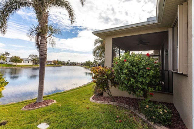 view of yard with a water view and ceiling fan