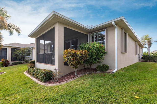 view of property exterior with a sunroom and a yard