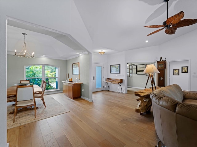 living room featuring vaulted ceiling, crown molding, ceiling fan with notable chandelier, and light hardwood / wood-style flooring