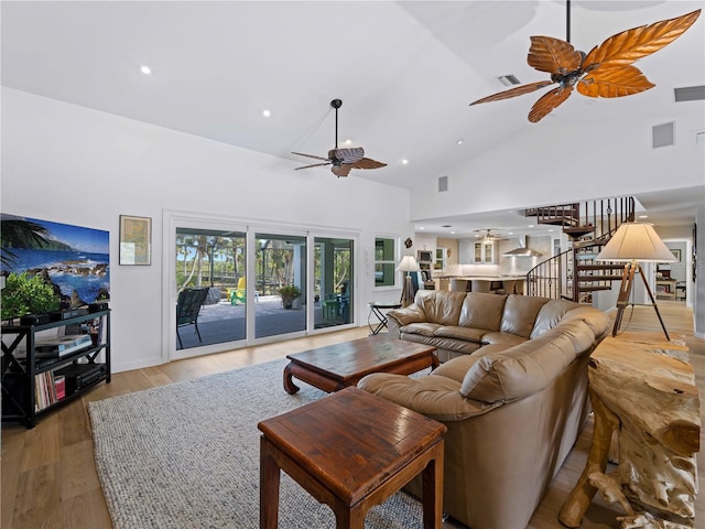 living room featuring high vaulted ceiling, light hardwood / wood-style floors, and ceiling fan