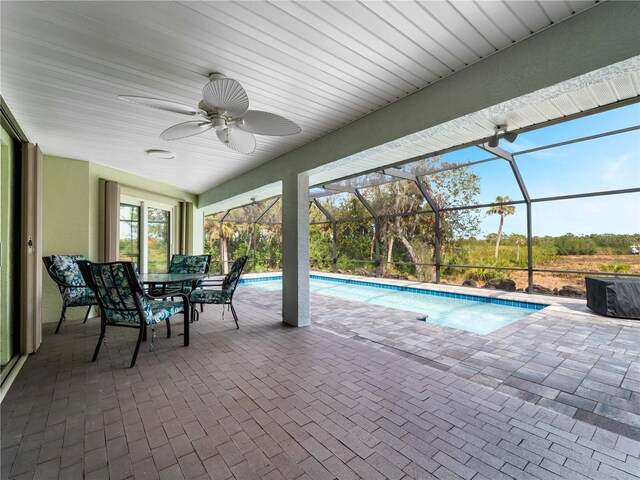 view of swimming pool featuring a lanai, ceiling fan, and a patio area