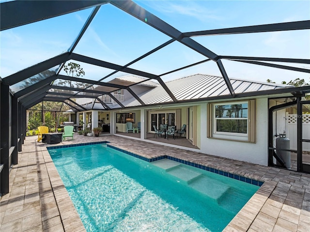 view of swimming pool featuring glass enclosure and a patio