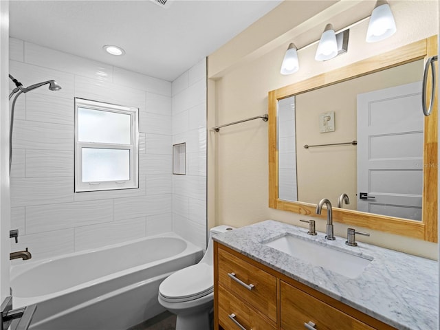 full bathroom with toilet, tiled shower / bath, and vanity