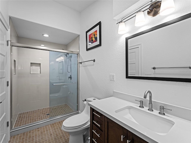 bathroom featuring toilet, vanity, tile patterned floors, and walk in shower