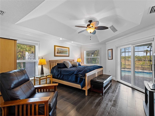 bedroom featuring ceiling fan, access to outside, a tray ceiling, and multiple windows