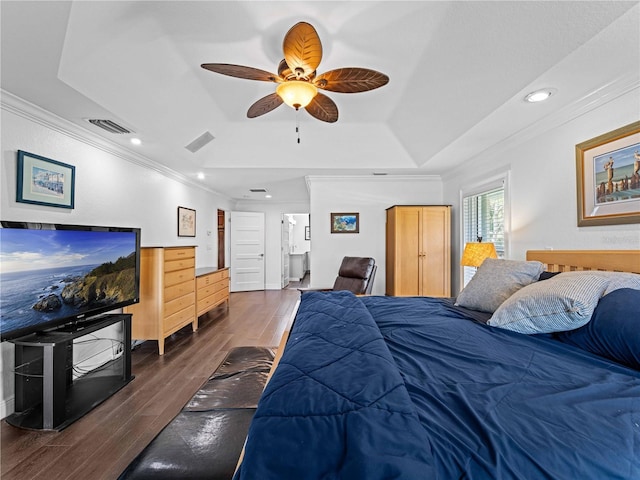 bedroom featuring dark wood-type flooring, ceiling fan, crown molding, and a raised ceiling