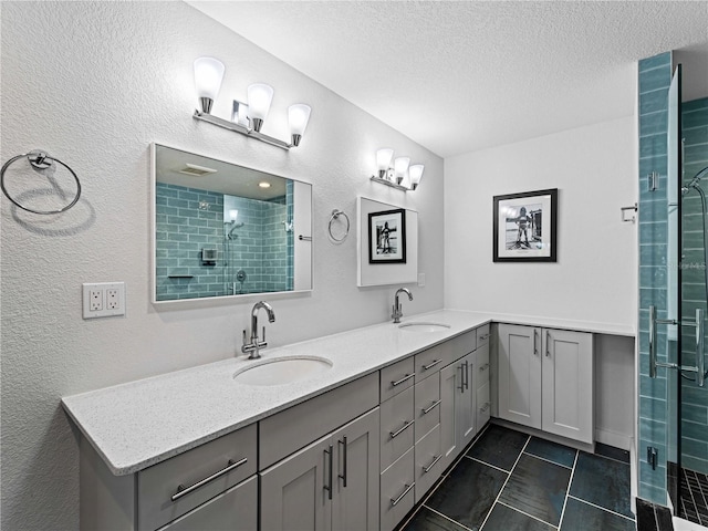 bathroom with a textured ceiling, tile patterned floors, vanity, and an enclosed shower