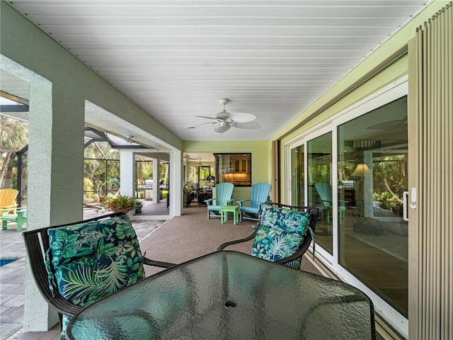 view of patio / terrace featuring ceiling fan and glass enclosure