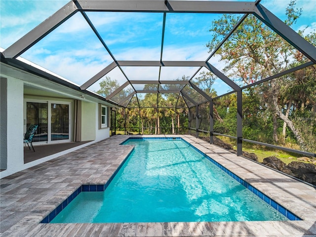 view of swimming pool featuring a lanai and a patio