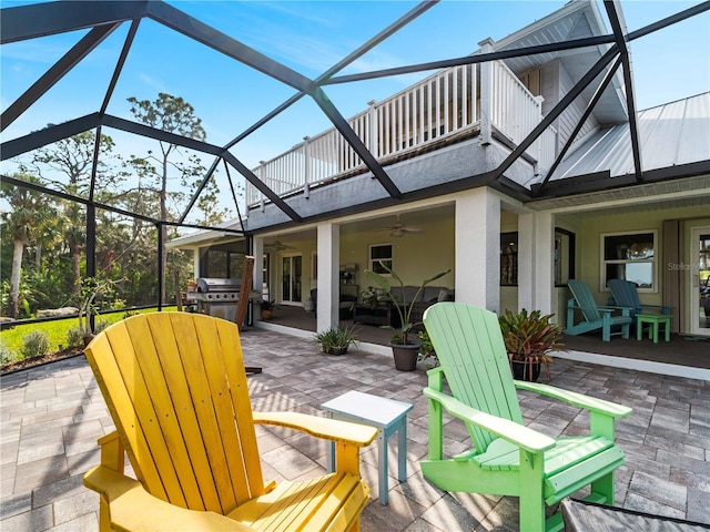 view of patio with ceiling fan, a grill, a balcony, and glass enclosure