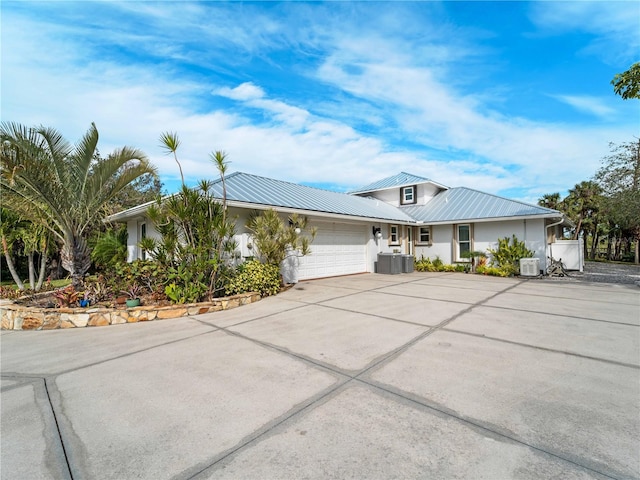 view of front of house with a garage and cooling unit