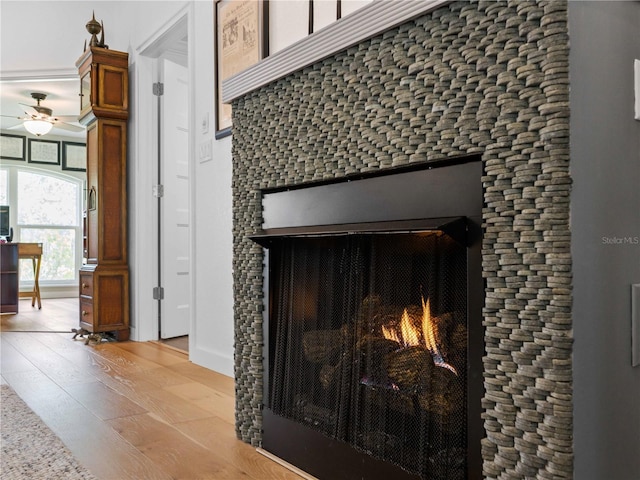 interior details with hardwood / wood-style flooring, ceiling fan, and a fireplace