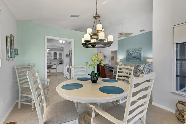 tiled dining room featuring ceiling fan with notable chandelier