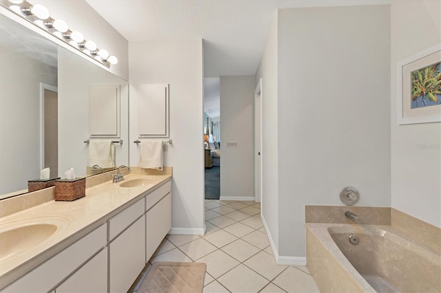 bathroom with a textured ceiling, a tub, tile patterned floors, and vanity