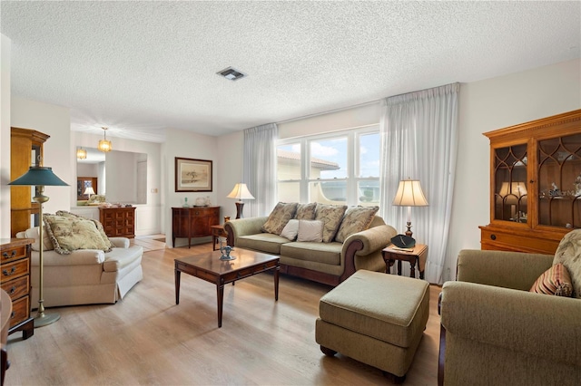 living room with light hardwood / wood-style floors and a textured ceiling