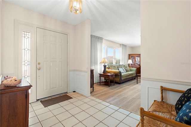 tiled foyer entrance with a textured ceiling