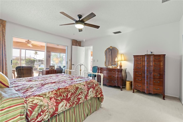 carpeted bedroom with ceiling fan and a textured ceiling