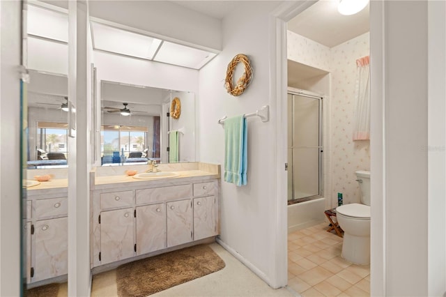 full bathroom featuring toilet, ceiling fan, tile patterned floors, vanity, and shower / bath combination with glass door