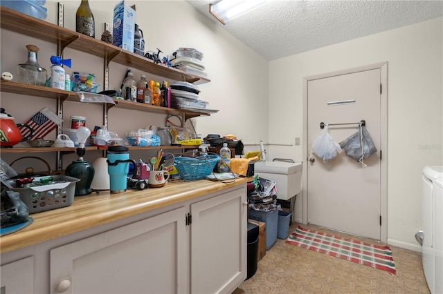 laundry room with separate washer and dryer and a textured ceiling