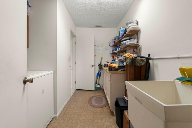 laundry area featuring washer / clothes dryer and a textured ceiling