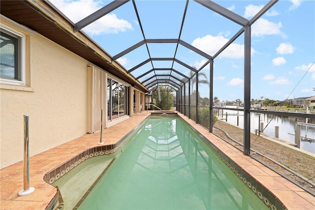 view of pool featuring a patio area, glass enclosure, and a water view