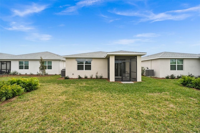 back of house featuring a sunroom, a yard, and central AC