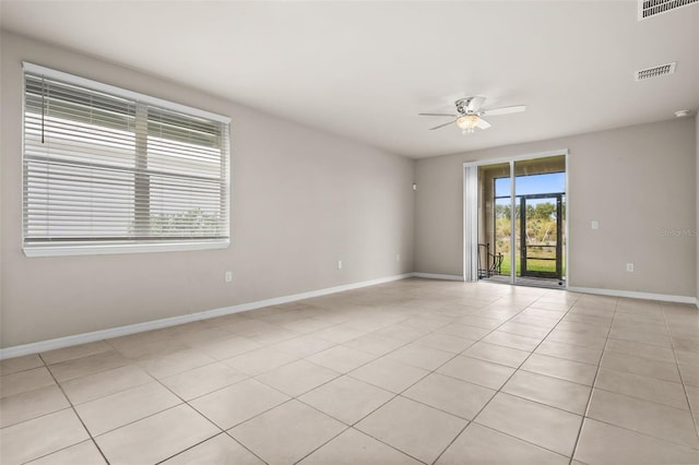 empty room with ceiling fan and light tile patterned floors